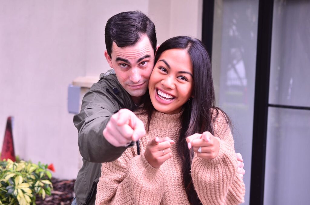 Photo of a Couple Smiling and Pointing