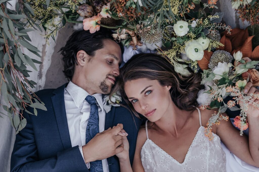 Man And Woman Lying On A Bed Of Flowers