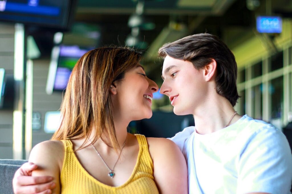 Young romantic multiethnic couple hugging and looking at each other while spending time together in cafe