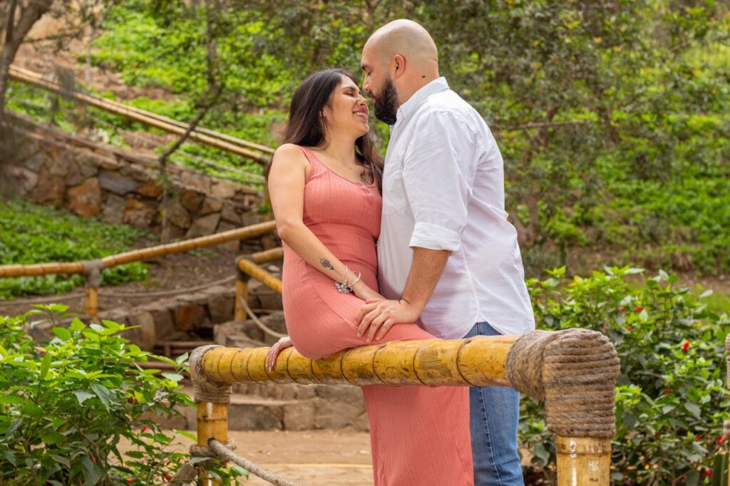 Bearded Man Standing Face to Face with Woman Sitting on Bamboo Pole