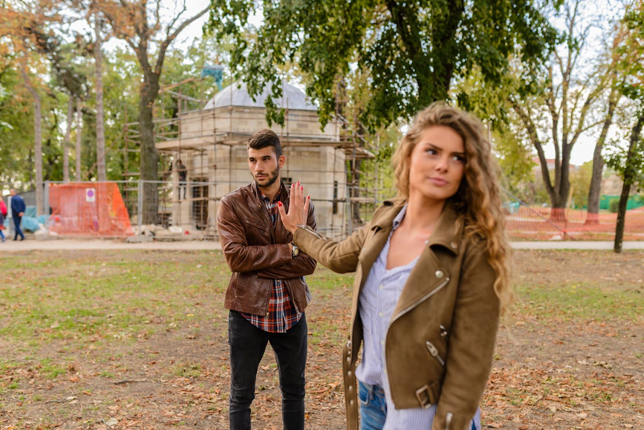 Man and Woman in Brown Leather Coat Standing on Brown Soil